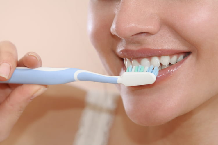 A woman is brushing teeth to avoid Tooth Gets Knocked Out