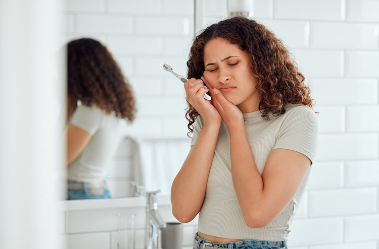 a photo of a woman with tooth pain and tooth abscess symptoms