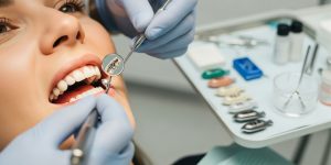 Close-up of a patient during a dental exam where a dentist checks for cavities and old fillings. Learn the facts about fillings and check-ups.